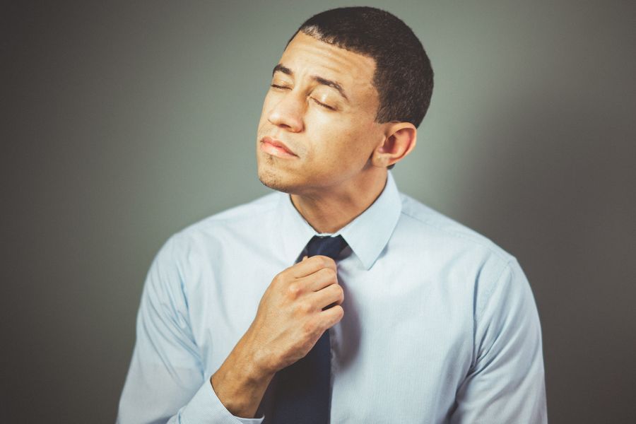 man adjusting tie