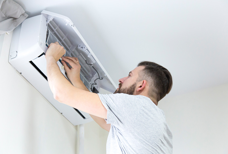 Technician cleaning heat pump