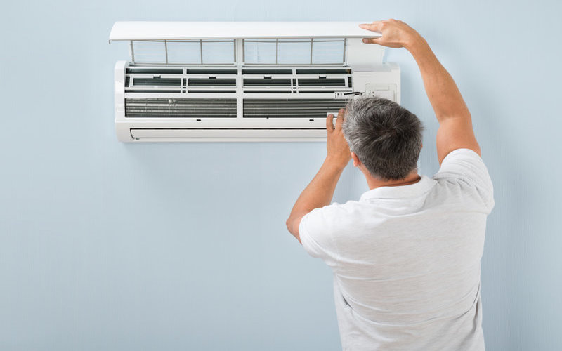Man-cleaning-heat-pump-filters