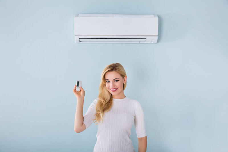 Happy woman using Mitsubishi Electric air conditioner